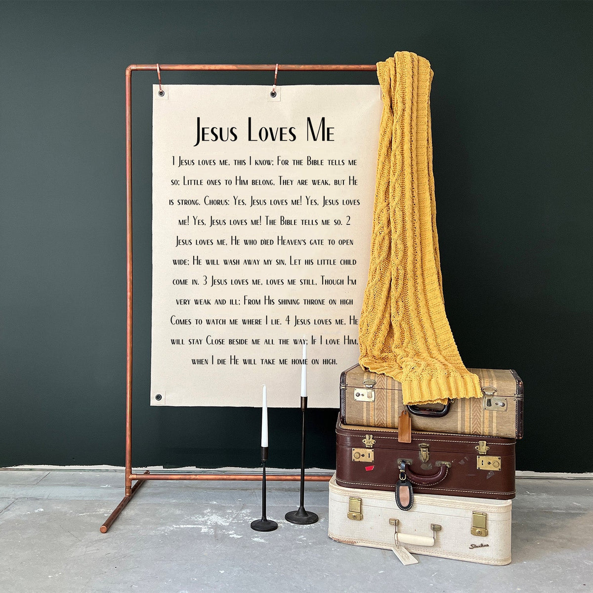 Jesus Loves me banner hanging on a copper stand