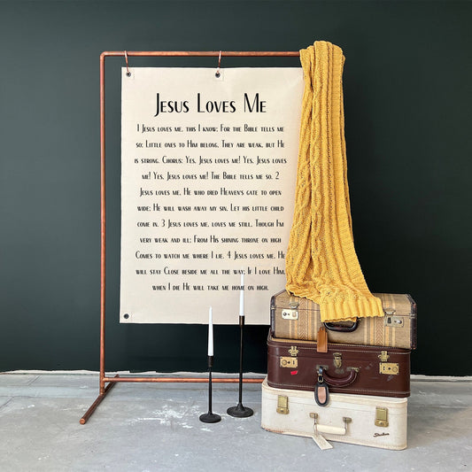 Jesus Loves me banner hanging on a copper stand