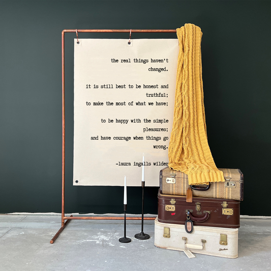 Wall Canvas with Laura Ingalls Wilder quote printed in black letters.